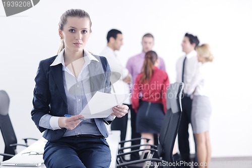 Image of business woman standing with her staff in background