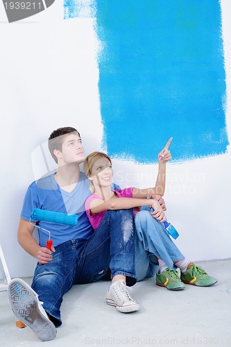 Image of happy young cople relaxing after painting in new home