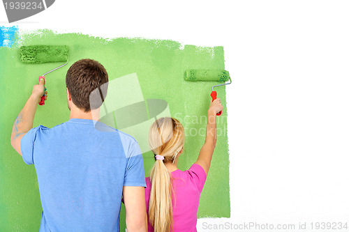 Image of happy couple paint wall at new home