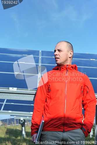 Image of engineer using laptop at solar panels plant field