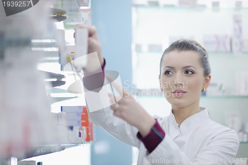 Image of pharmacist chemist woman standing in pharmacy drugstore