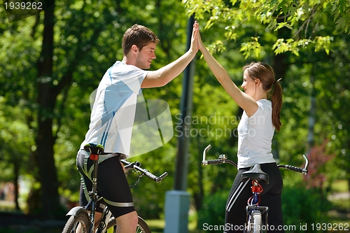 Image of Happy couple ridine bicycle outdoors