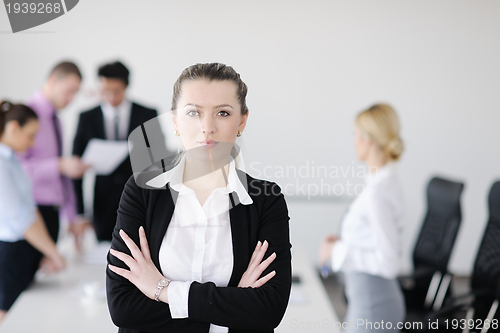Image of business woman standing with her staff in background