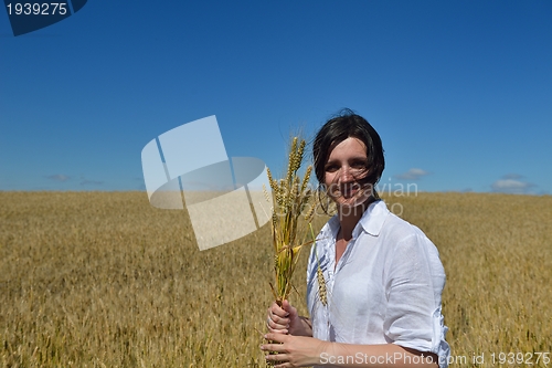 Image of young woman in wheat field at summer