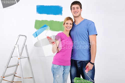 Image of happy couple paint wall at new home