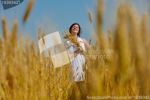 Image of young woman in wheat field at summer