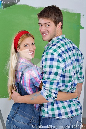 Image of happy couple paint wall at new home