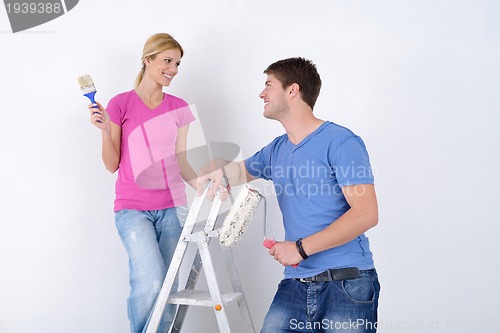 Image of happy couple paint wall at new home