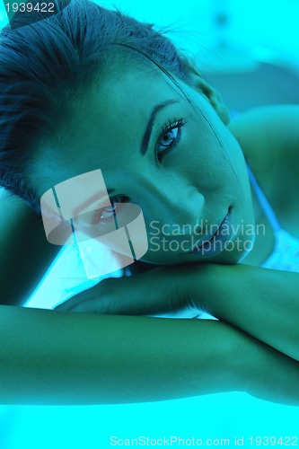 Image of Beautiful young woman tanning in solarium