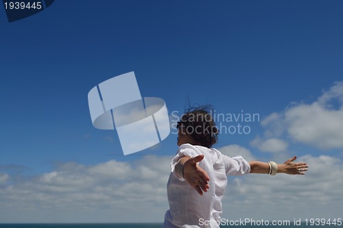 Image of happy young woman with spreading arms to sky
