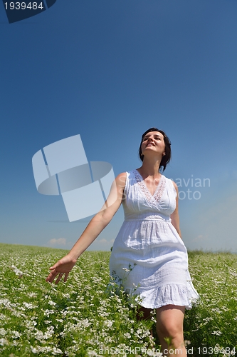 Image of Young happy woman in green field