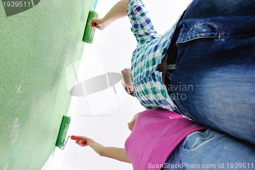 Image of happy couple paint wall at new home