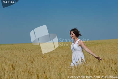 Image of young woman in wheat field at summer