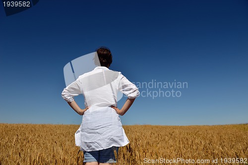 Image of young woman in wheat field at summer