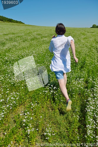 Image of Young happy woman in green field