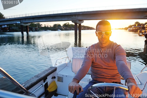 Image of portrait of happy young man on boat