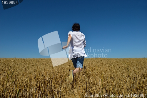 Image of young woman in wheat field at summer