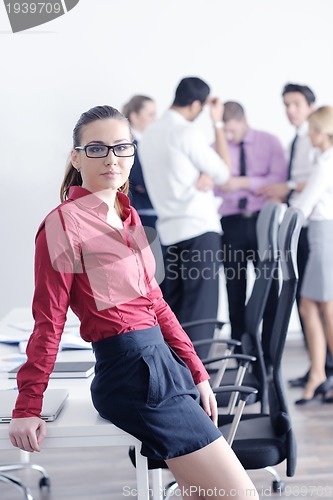 Image of business woman standing with her staff in background