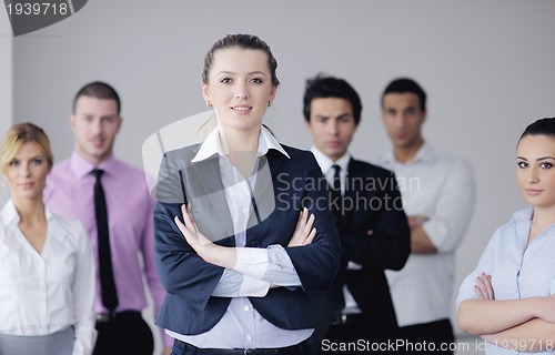 Image of business woman standing with her staff in background