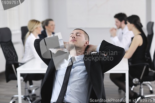 Image of handsome young business man with colleagues in background