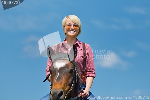 Image of happy woman  on  horse