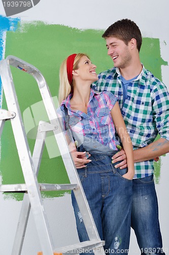 Image of happy couple paint wall at new home