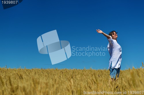 Image of young woman in wheat field at summer