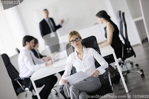 Image of business woman with her staff in background