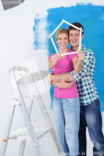 Image of happy couple paint wall at new home