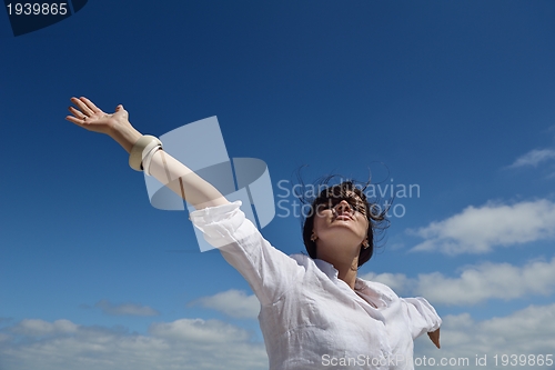 Image of young woman with spreading arms to sky
