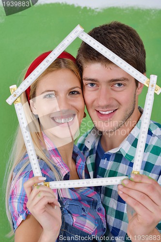 Image of happy couple paint wall at new home
