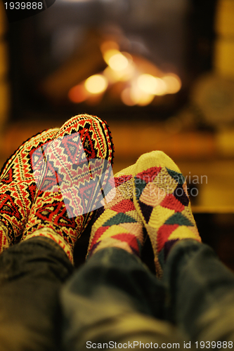 Image of Young romantic couple relax on sofa in front of fireplace at hom