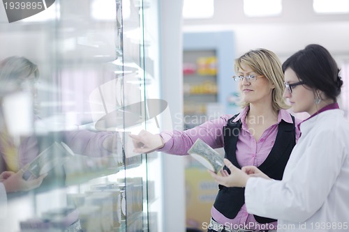 Image of pharmacist suggesting medical drug to buyer in pharmacy drugstor