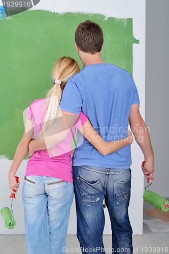 Image of happy couple paint wall at new home