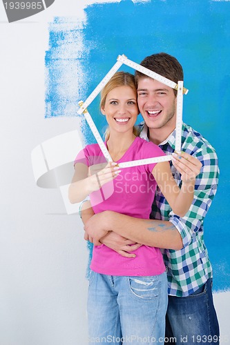 Image of happy couple paint wall at new home