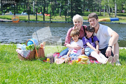 Image of Happy family playing together in a picnic outdoors