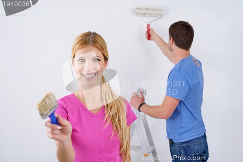 Image of happy couple paint wall at new home