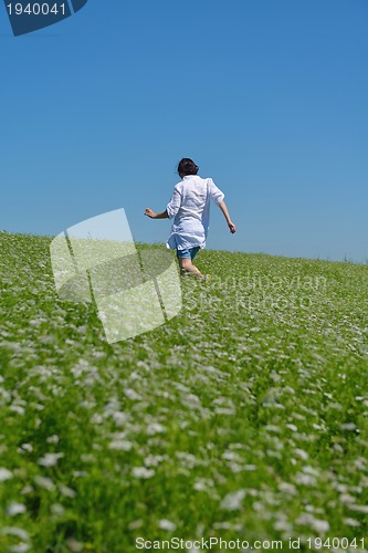 Image of Young happy woman in green field