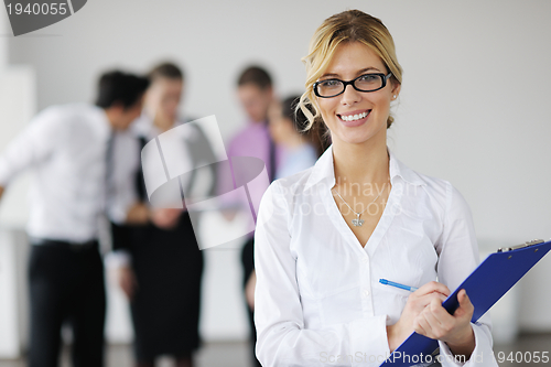 Image of business woman standing with her staff in background