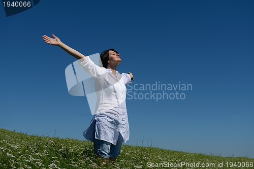 Image of Young happy woman in green field