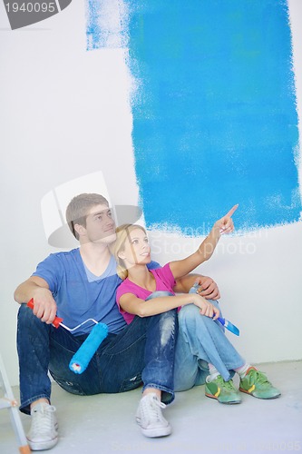 Image of happy young cople relaxing after painting in new home