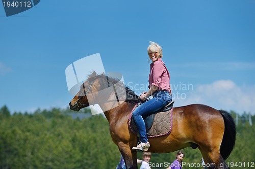 Image of happy woman  ride  horse