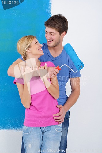 Image of happy couple paint wall at new home