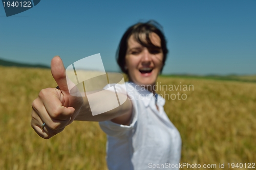 Image of young woman in wheat field at summer