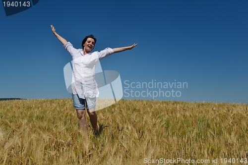 Image of young woman in wheat field at summer