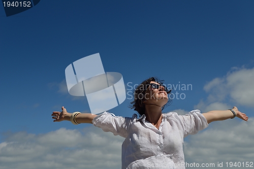 Image of young woman with spreading arms to sky