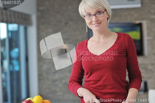 Image of happy  beautiful blonde  woman prepare food in  the kitchen