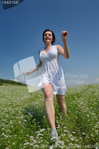Image of Young happy woman in green field