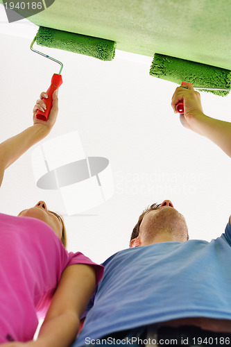 Image of happy couple paint wall at new home