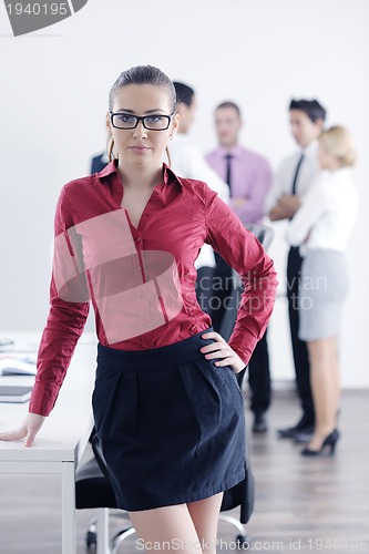 Image of business woman standing with her staff in background